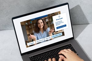 A laptop screen shows a trainee learning from Retorio's human liked training software