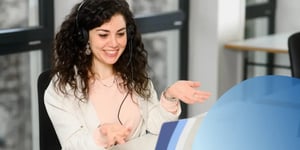 Lady sitting at a desk with a headset talking on a call