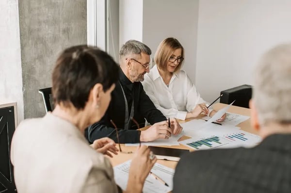 4 employees sitting around the table discussing 