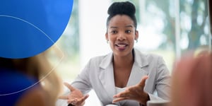 Woman facing the camera in talking motion with open hand gesture