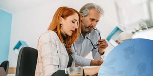 Männlicher und weiblicher Angestellter schauen in den Laptop-Bildschirm 