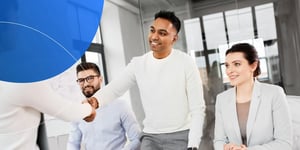 Man shaking hands with another employee and smiling