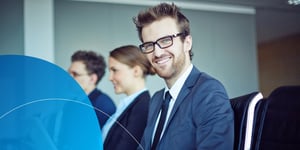 Man with glasses smiling to camera