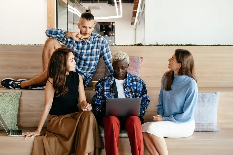 Retorio group of employees sitting on staircase discussing 